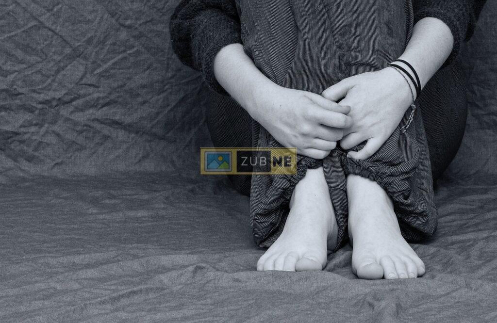 a girl sitting in a sad mood on the floor closing her arms on the legs, sad images on the zubne.com