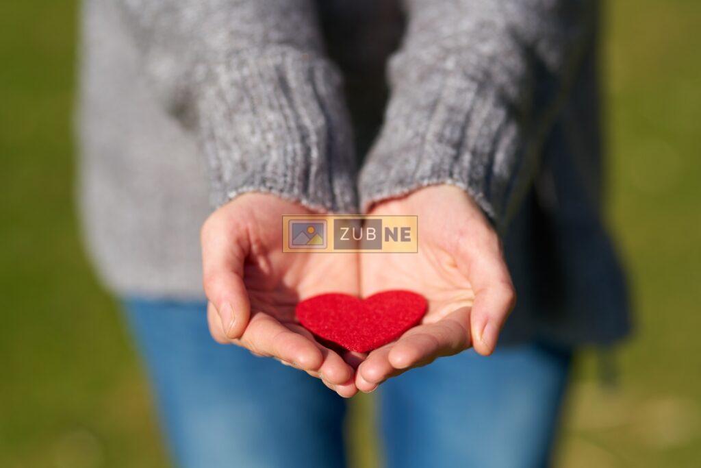 a girl holding a heart shape paper in her hands, anniversary image on zubne.com, free images on zubne.com