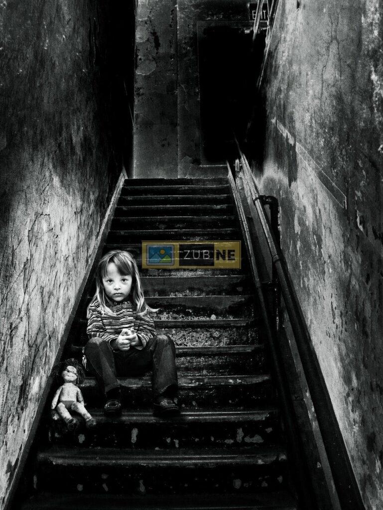 a young boy sitting on stair in a sad mood with a soft toy, sad images on zubne.com