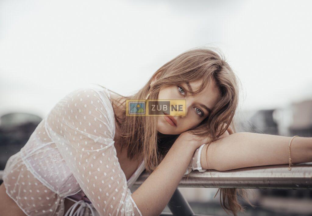 a blonde hair girl sitting on a bench in a sad mood wearing a white color top, sad images on zubne.com