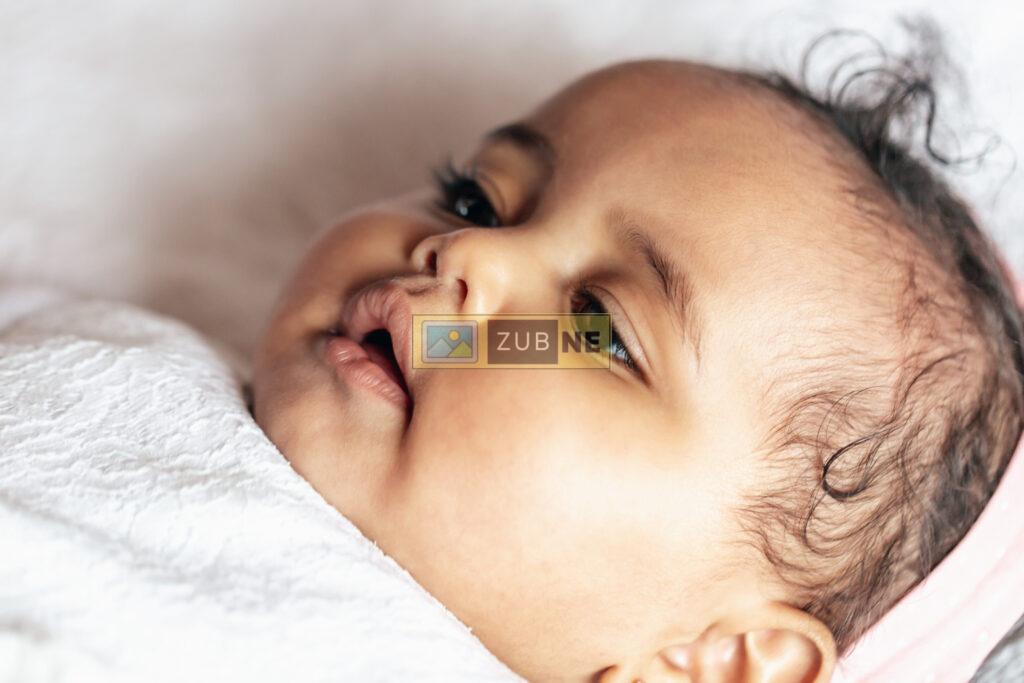 free baby images. a cute baby is resting on bed and wearing a white blanket